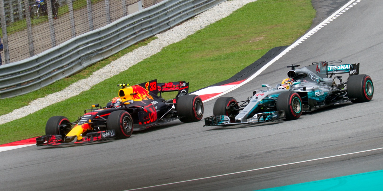 Max Verstappen in a Red Bull overtaking Lewis Hamilton in a Mercedes at the 2017 Malaysian Grand Prix